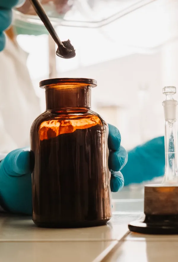 Operatore con flacone ambrato in laboratorio
